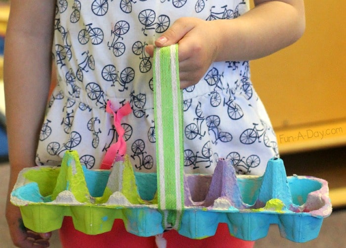 preschool holding a homemade easter basket made from an egg carton