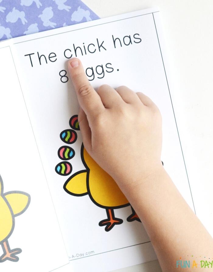 child's hand pointing to the word chick in a counting book printable
