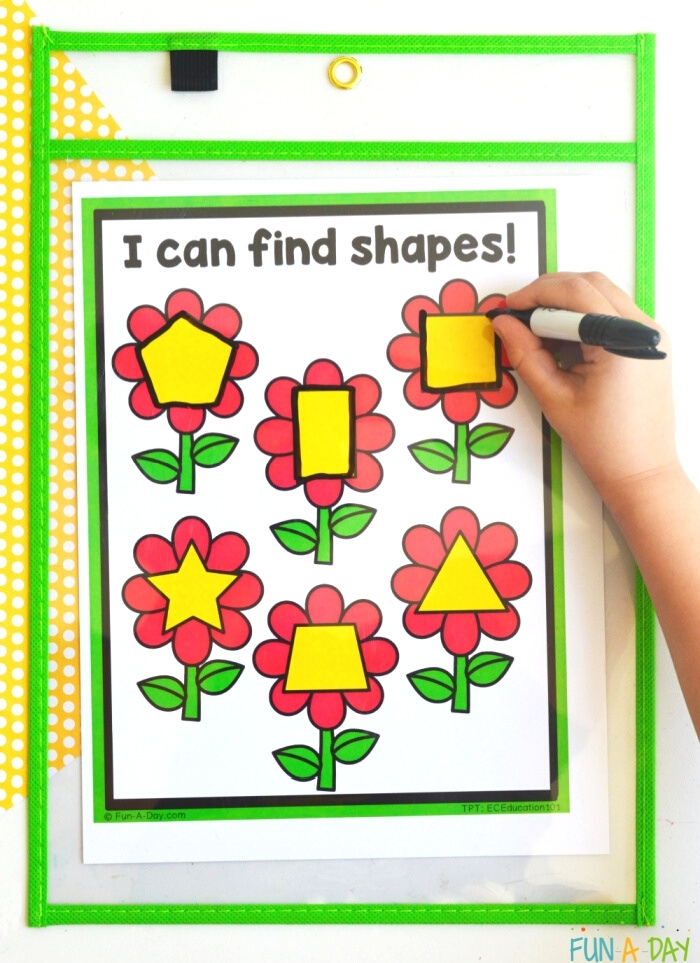child's hand tracing shapes on a flower shape mat