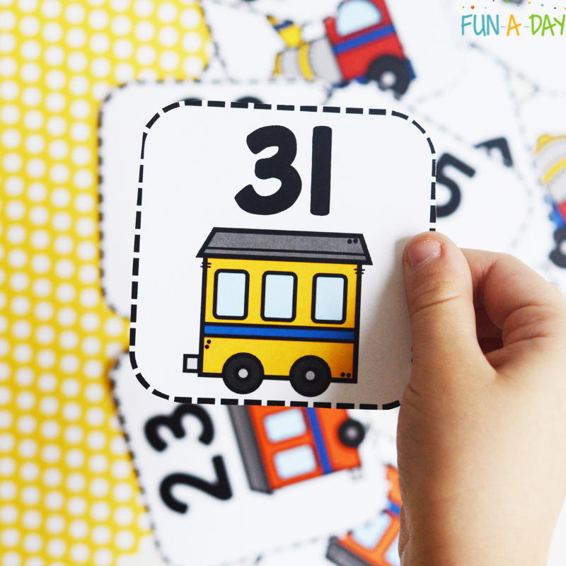 preschooler holding number 31 train printable card