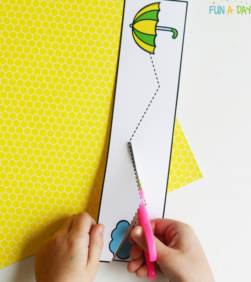child using scissors to cut a spring tracing page