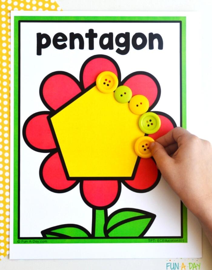 child's hand placing buttons on a pentagon flower shape mat