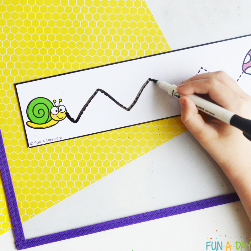 child using dry erase marker to trace over spring fine motor printable