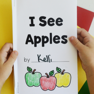 Preschooler holding an I See Apples printable book