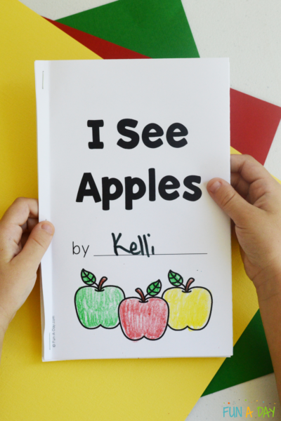 Preschooler holding an I See Apples printable book