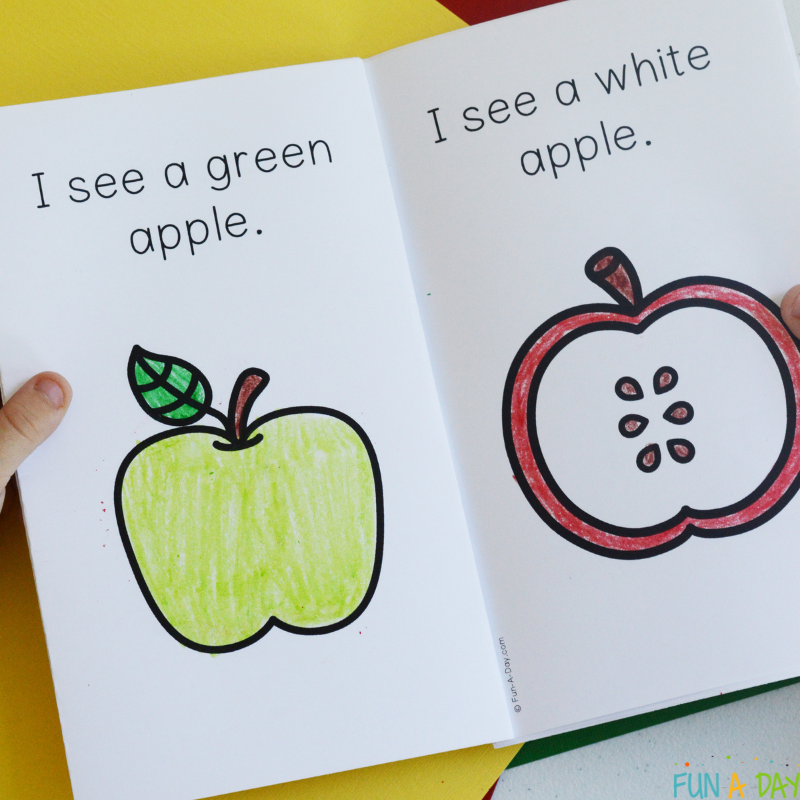 Preschooler holding open an I See Apples printable book