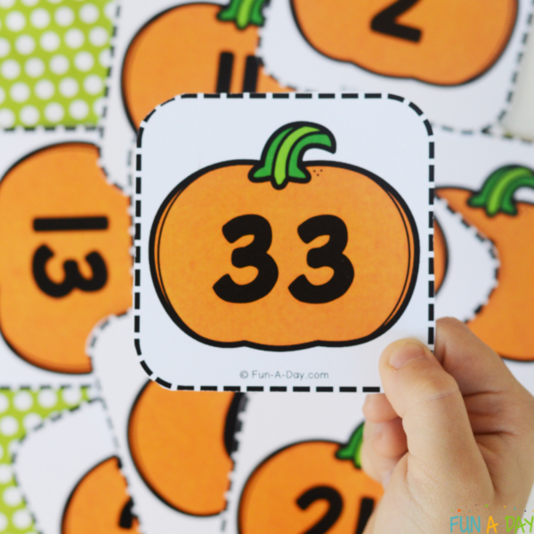 child holding pumpkin number card 33