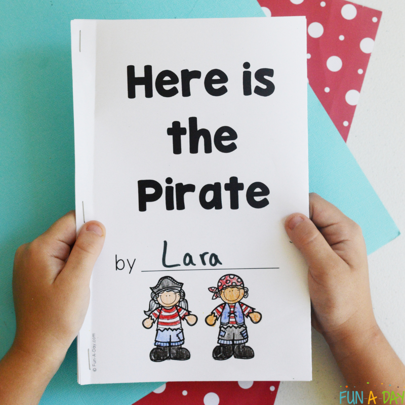 preschooler hands holding a printable book entitled here is the pirate
