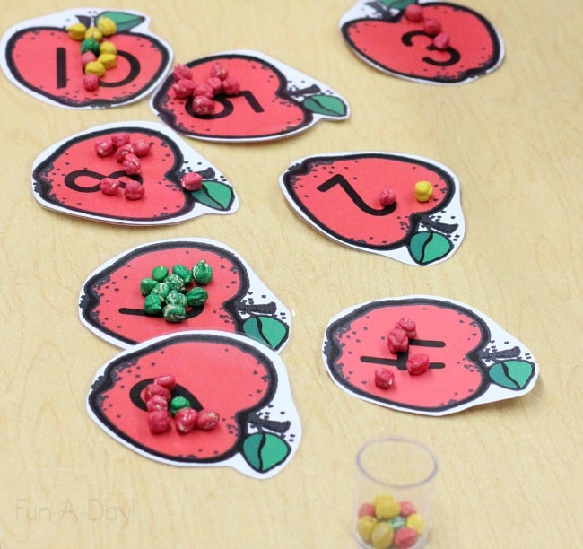 Printable apples with numbers, topped with dyed chickpeas to practice one-to-one correspondence
