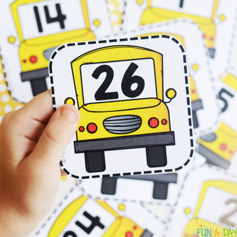 preschool hand holding the number 26 bus calendar card