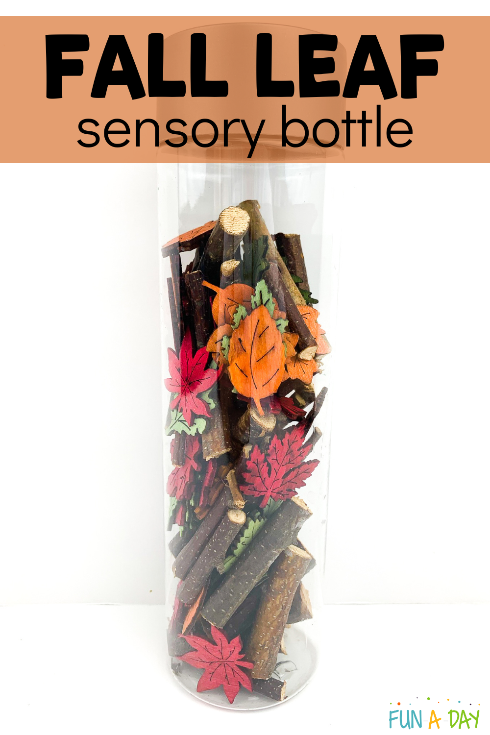 clear bottle with sticks and wooden leaves and text that reads fall leaf sensory bottle