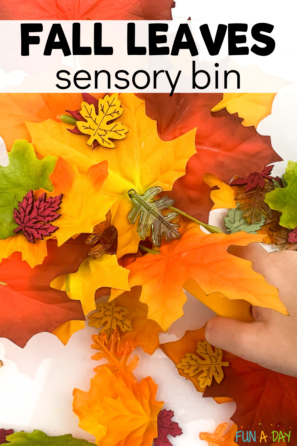 child's hand playing with leaves with text that reads fall leaves sensory bin