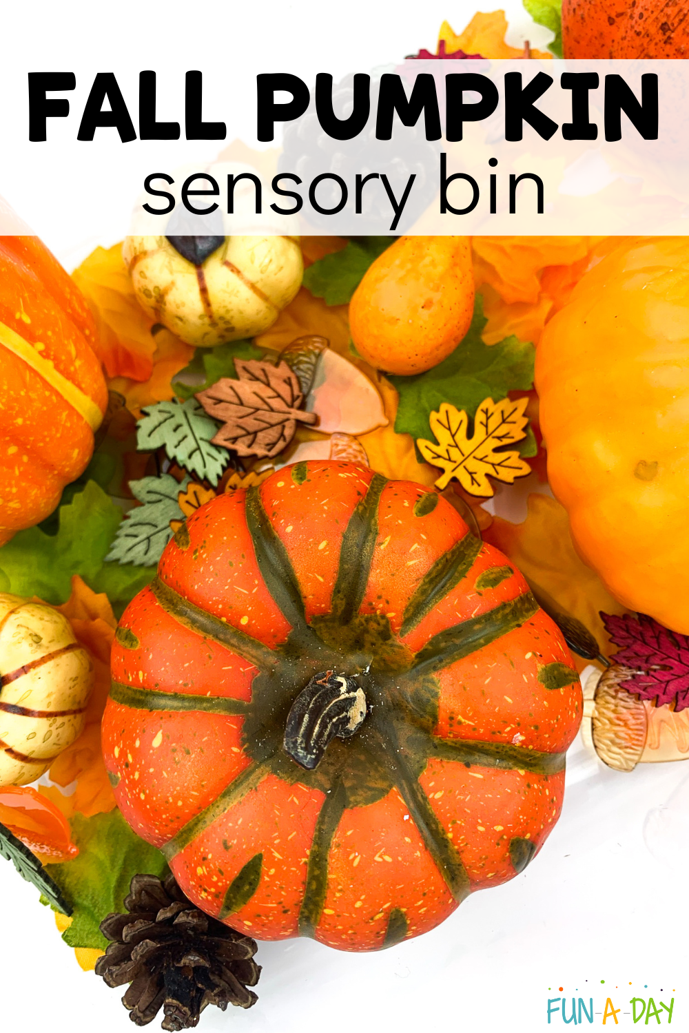fake pumpkins and leaves with text that reads fall pumpkin sensory bin