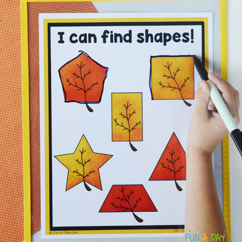 child using dry erase markers to trace shapes on leaf shape mats printable