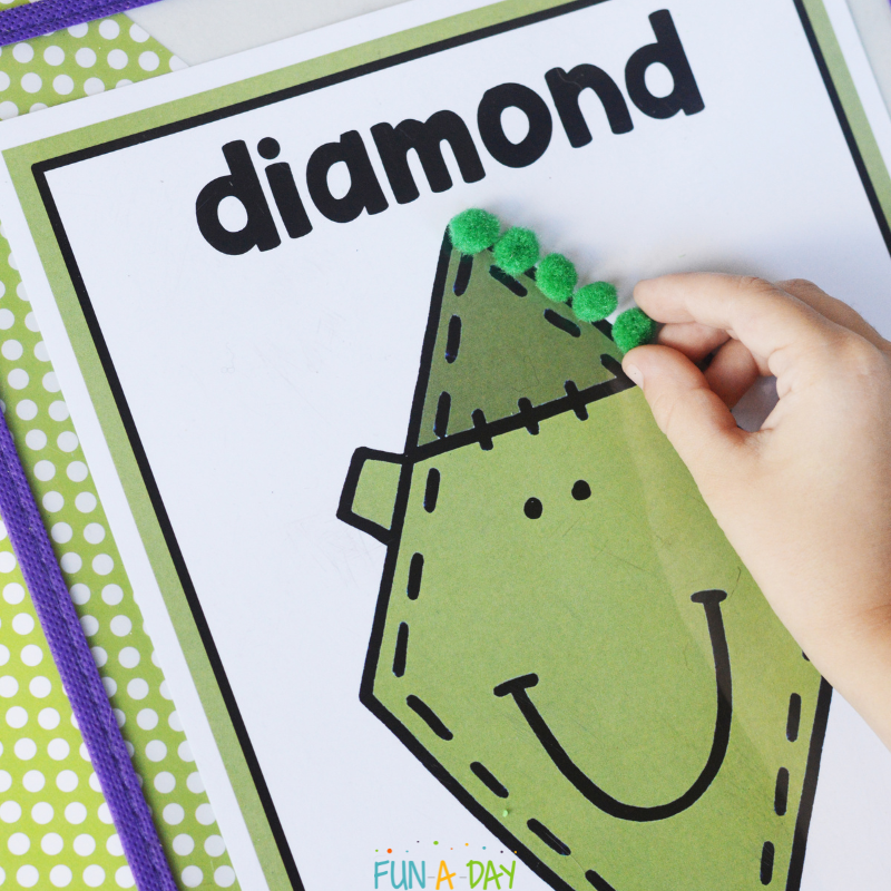 child placing pompoms on monster shape mat printable