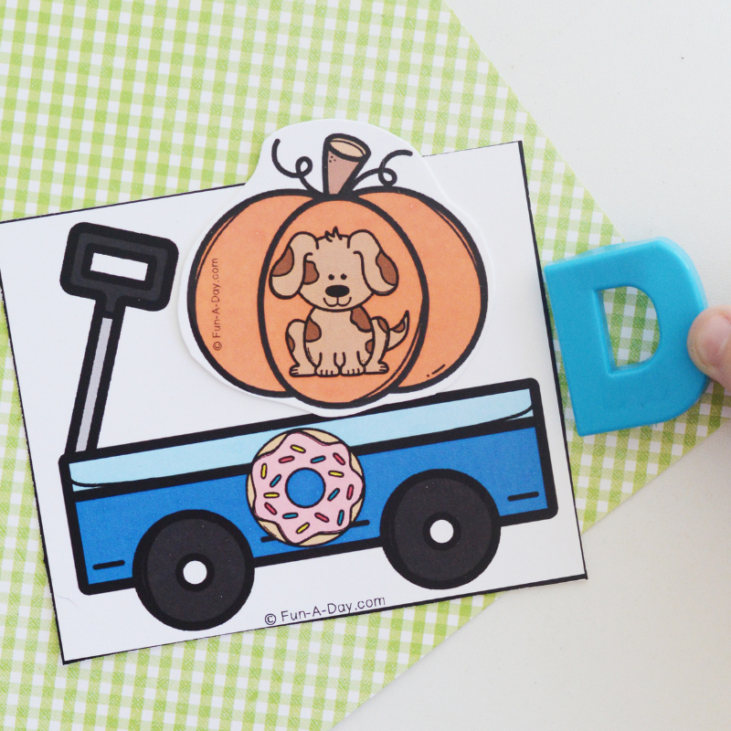 child matching letter D to dog and doughnut pumpkin beginning sounds card