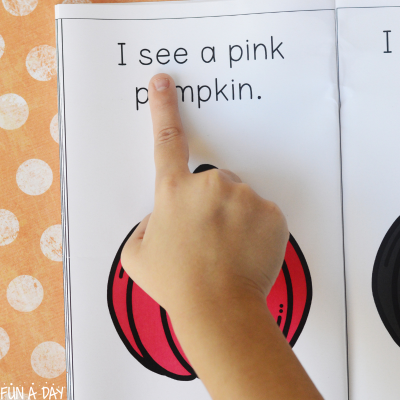 child's finger pointing to read I see a pink pumpkin