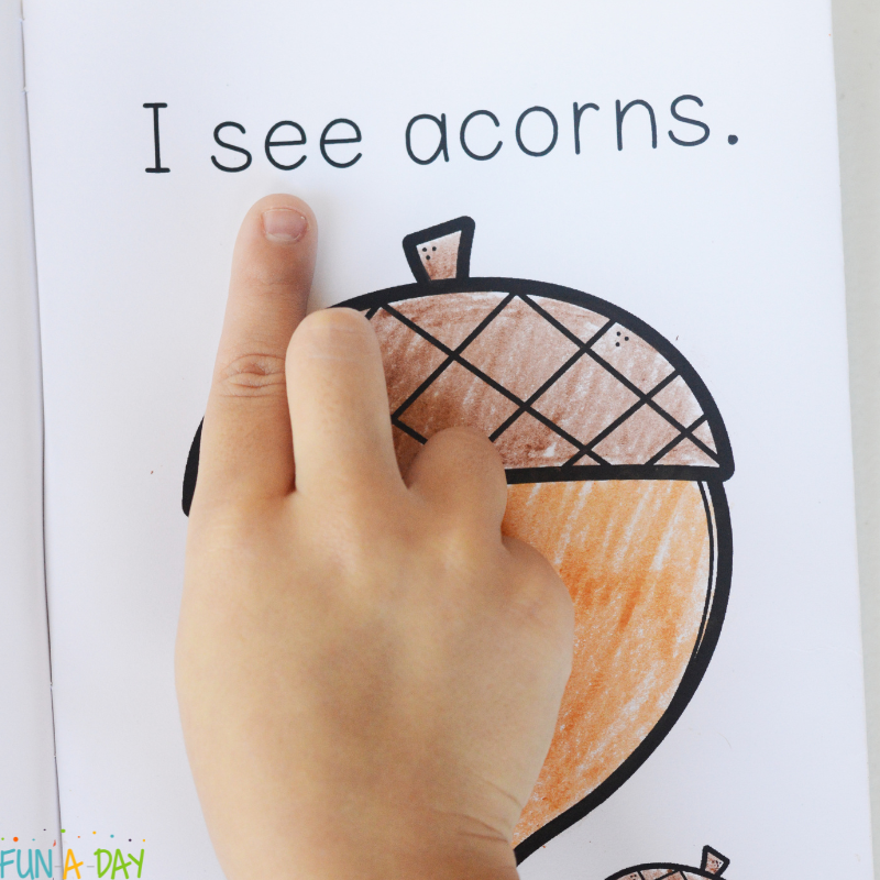 child's hand pointing to the word see in I see fall printable book