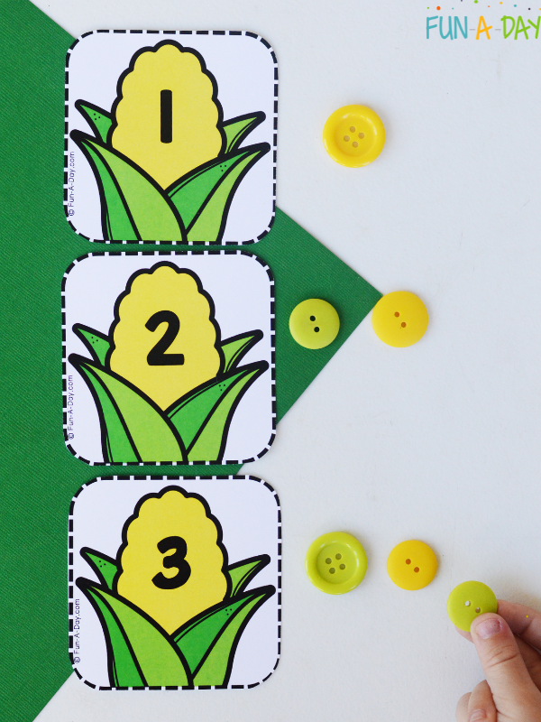 corn calendar numbers 1, 2, and 3 with child placing buttons next to each