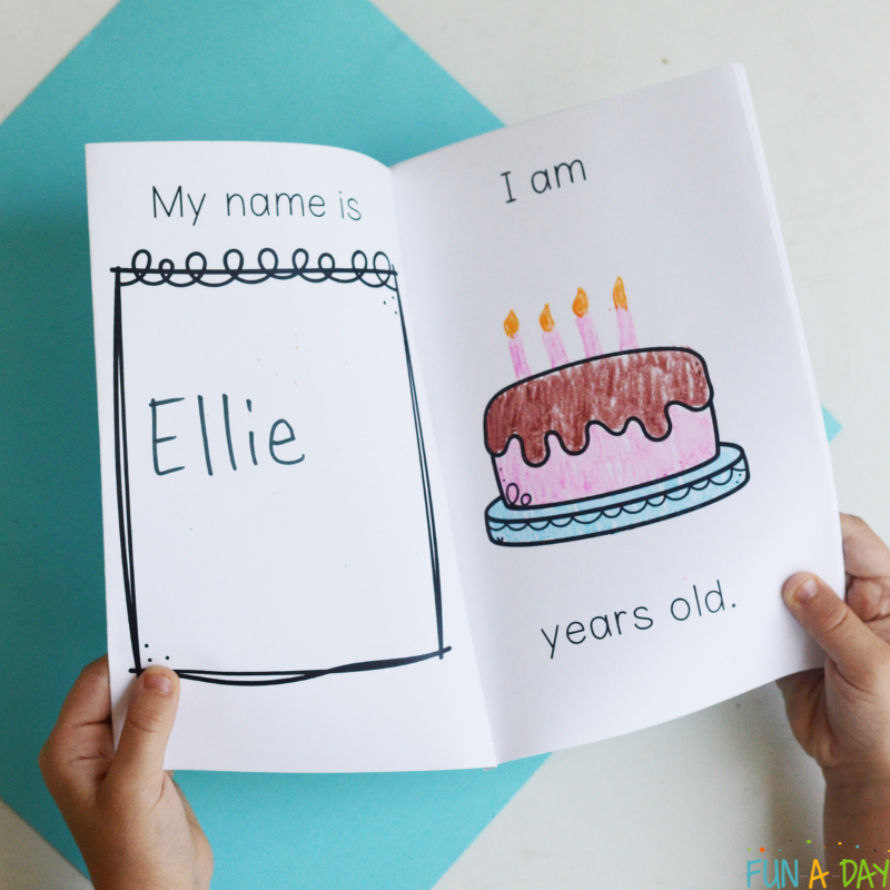 child holding all about me book open to page with name and age
