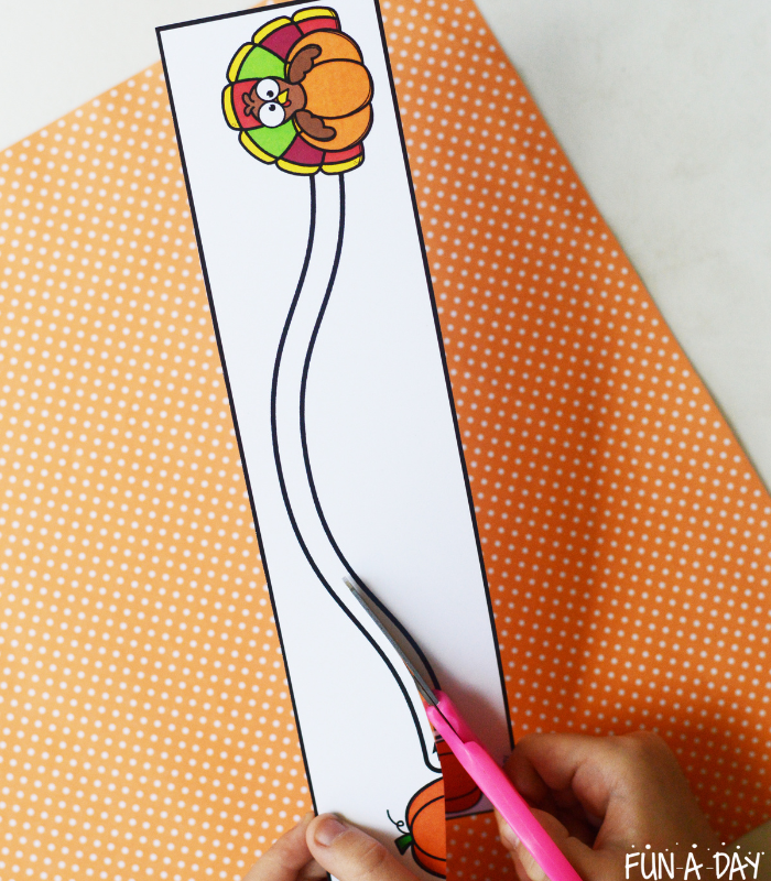 child using scissors on thanksgiving cutting practice printable