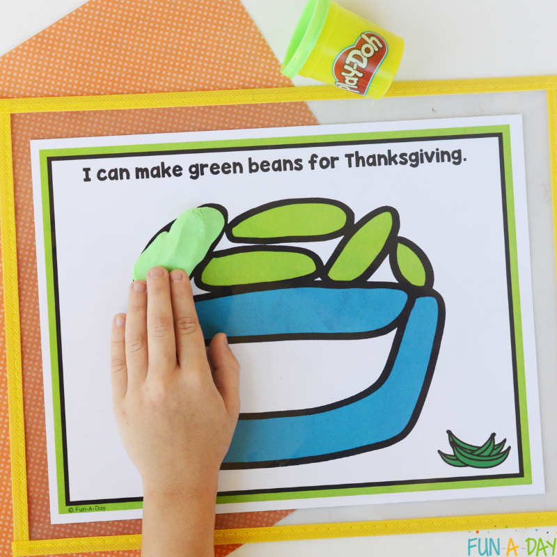 child using green play dough with thanksgiving playdough mats
