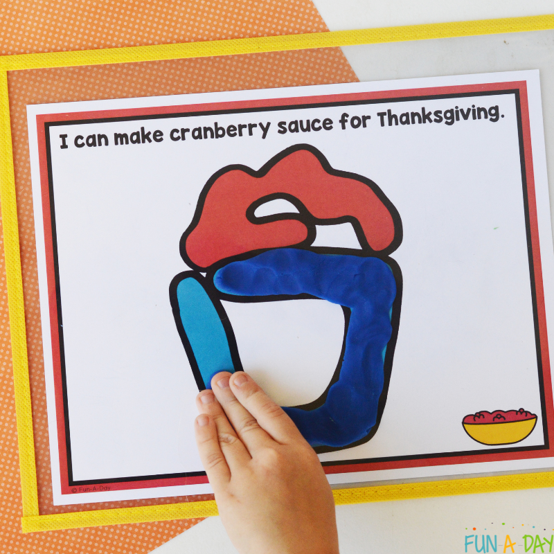 preschooler hand adding play dough to Thanksgiving playdough mats