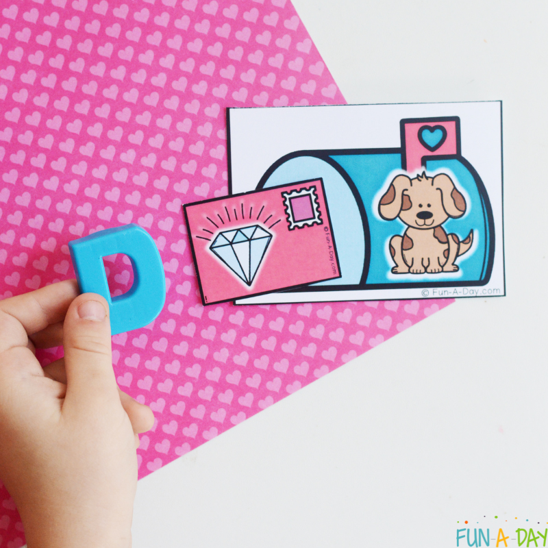 child matching magnetic letter D to valentine-themed beginning sounds picture card printable