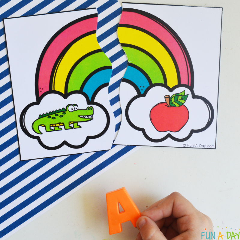 child matching magnetic letter A to rainbow beginning sound puzzle with alligator and apple pictured