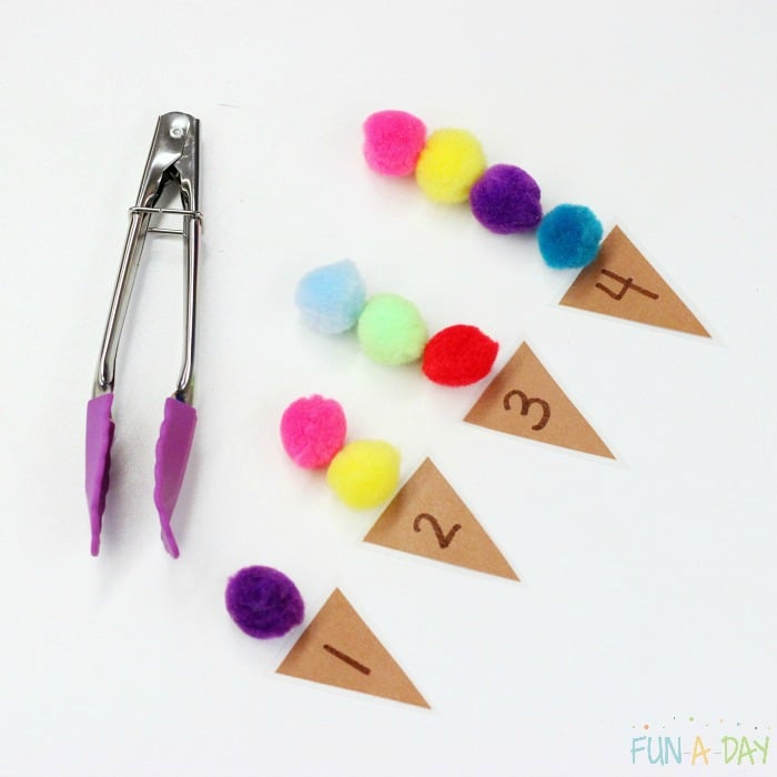 kid-sized tongs and numbered triangles 1 through 4 with pompoms on top for ice cream counting