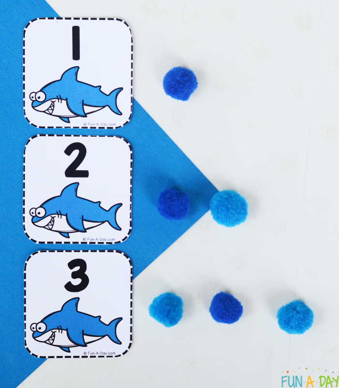 shark calendar numbers 1, 2, 3 with corresponding number of blue pompoms next to each