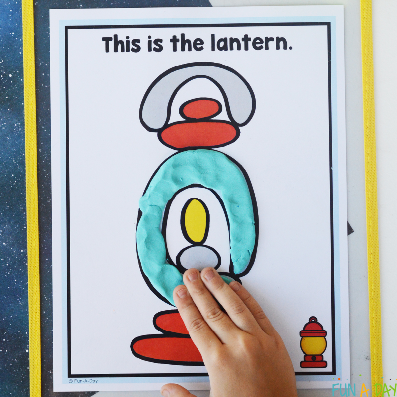 child using one of the camping playdough mats to form a lantern