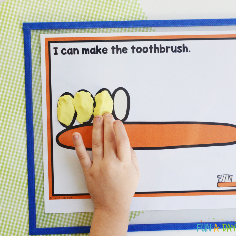 preschooler using play dough to make a toothbrush