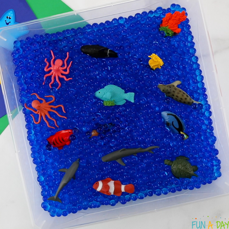 sea animal toys in bin of blue water beads