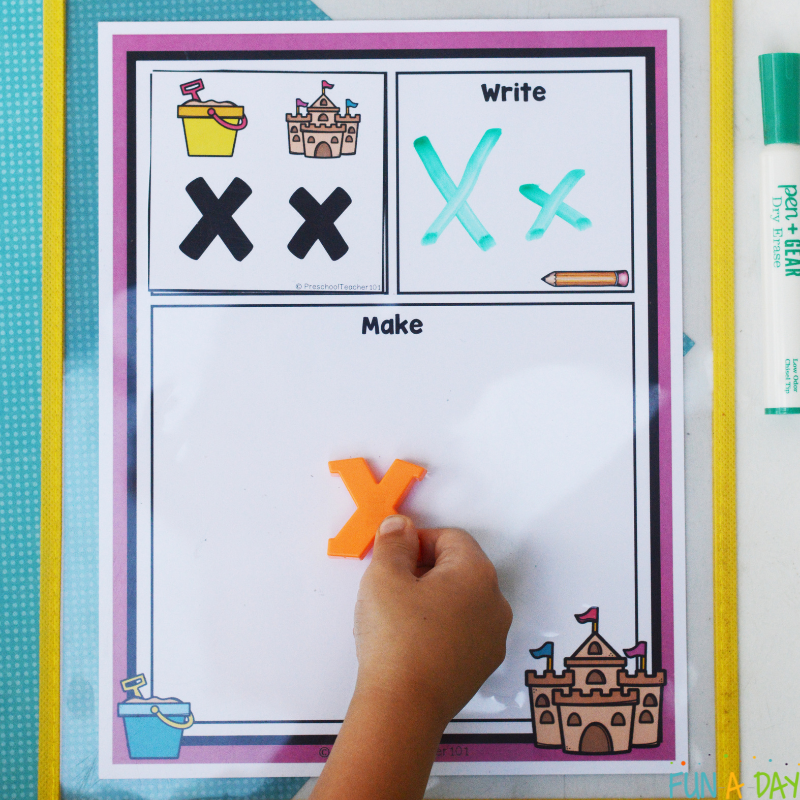 child placing magnetic letter x after writing the letter on read it build it write it printable