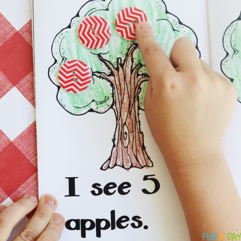 child adding buttons while using a counting apples printable book