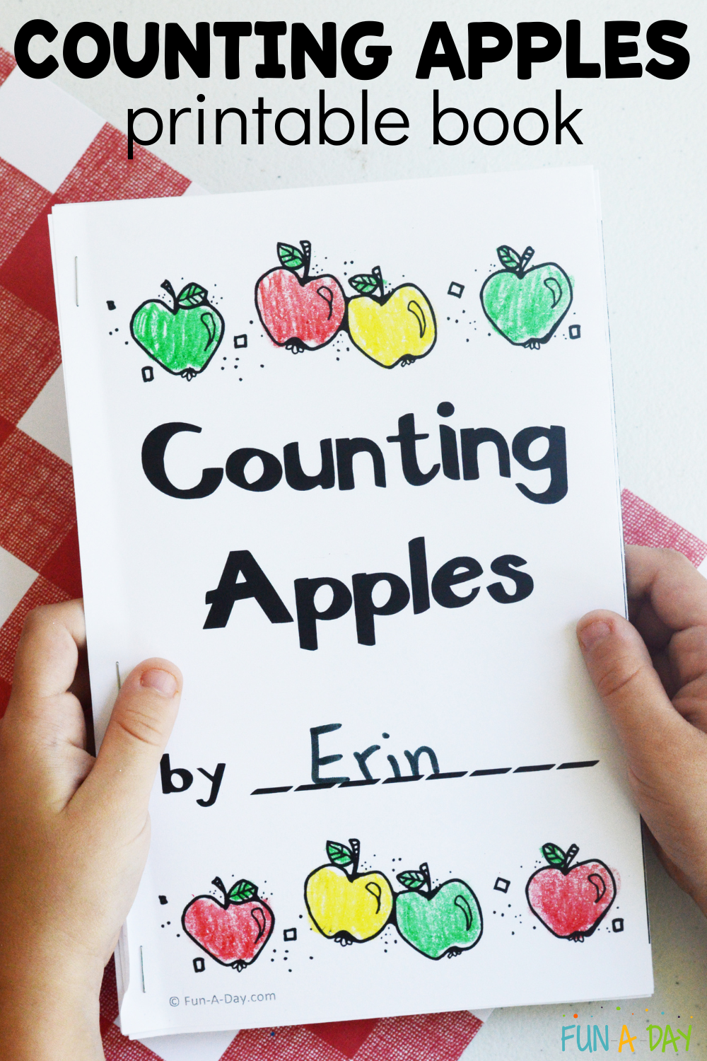 child holding an emergent reader with text that reads counting apples printable book