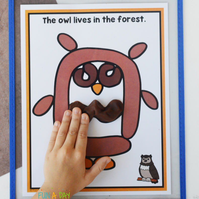 preschooler putting dough on owl playdough mat