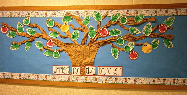 apple bulletin board made with crumpled brown paper and kids' handprint apples and handprint leaves