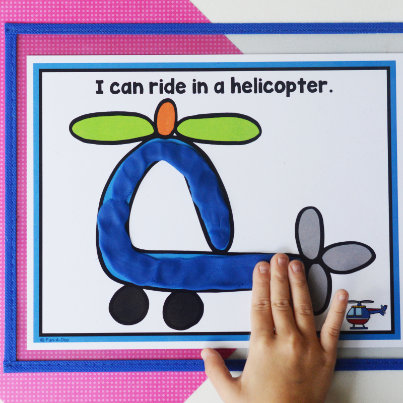 Preschooler putting blue dough on a transportation playdough mat that reads I can ride in a helicopter.