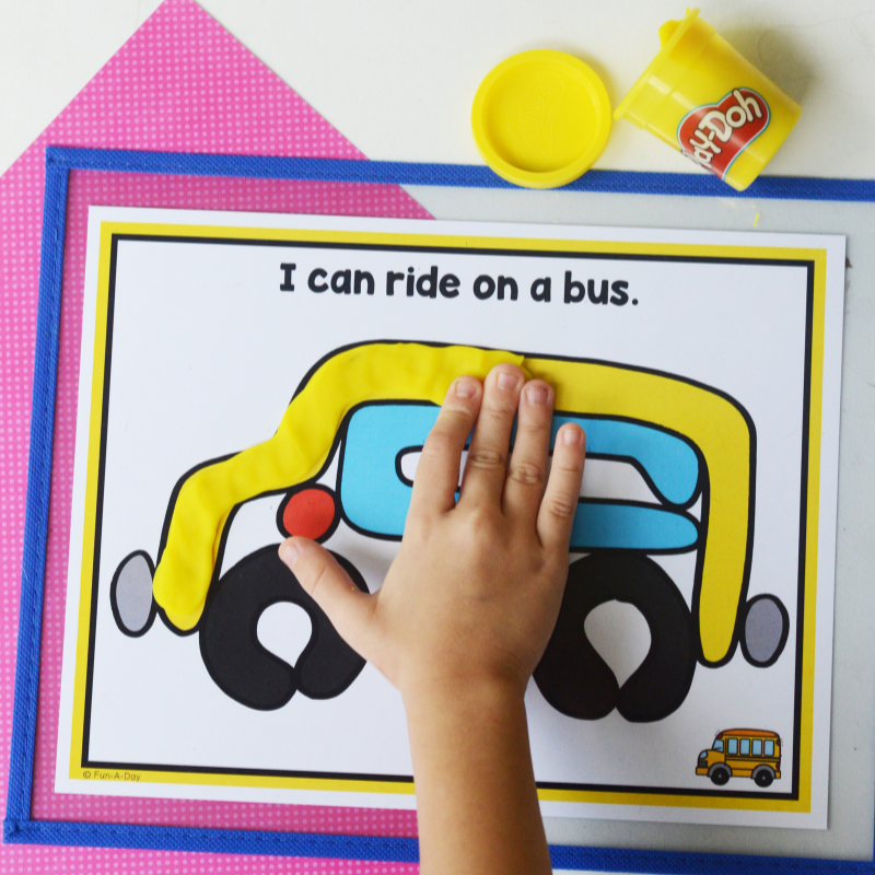 child putting yellow dough on one of the transportation playdough mats that reads I can ride on a bus.
