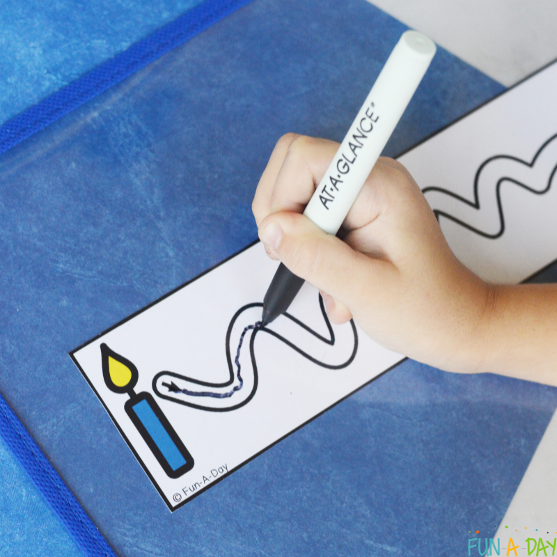 A dry-erase marker drawing on the path of a Hanukkah cutting strip.