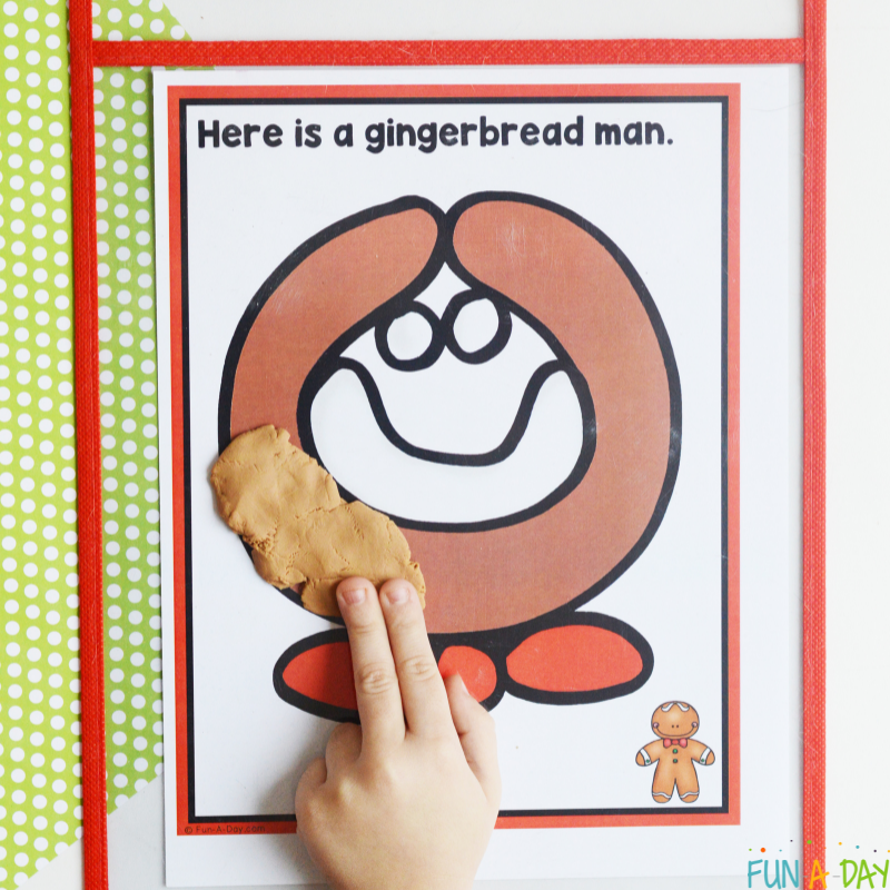 child using brown play dough to make a gingerbread man