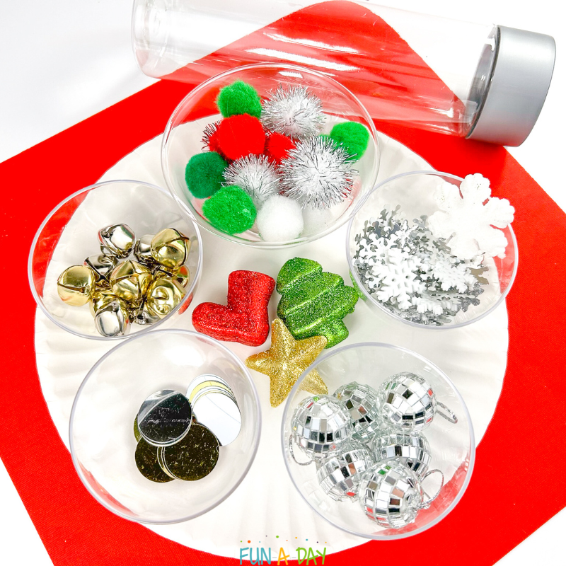 materials to make a christmas sensory bottle - pom poms, bells, snowflakes, ornaments