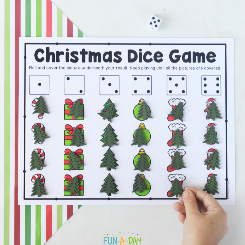 child placing manipulative on printable christmas dice game
