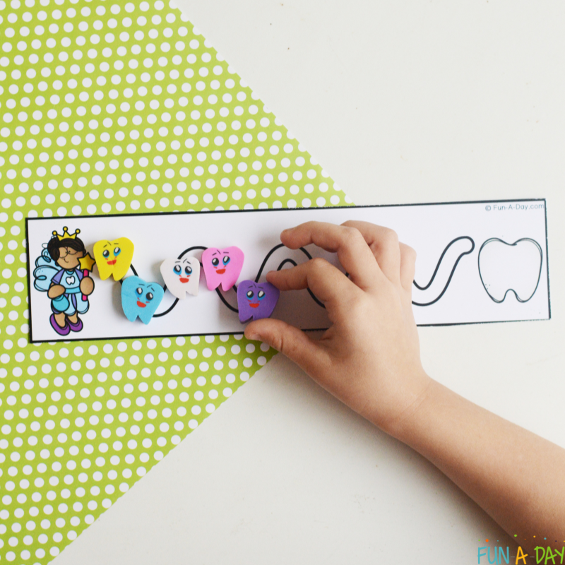 child placing tooth mini erasers on dental cutting strips