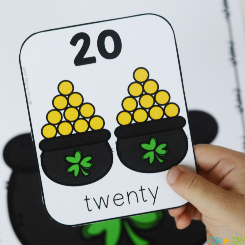 preschooler holding one of the pot of gold number cards, number 20
