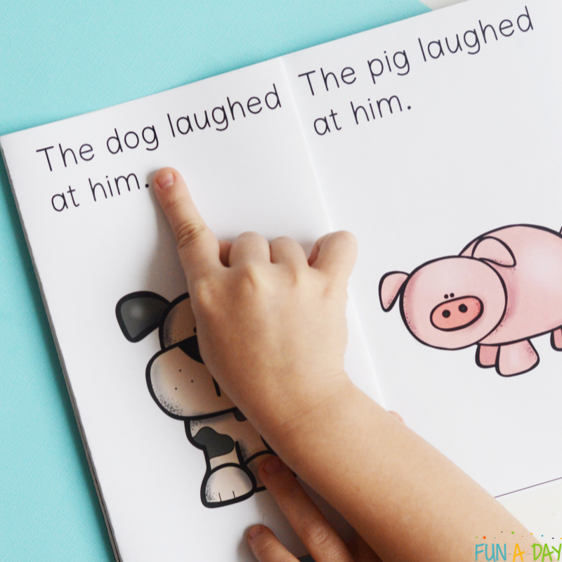 child pointing to words in the hat printable book that reads the dog laughed at him