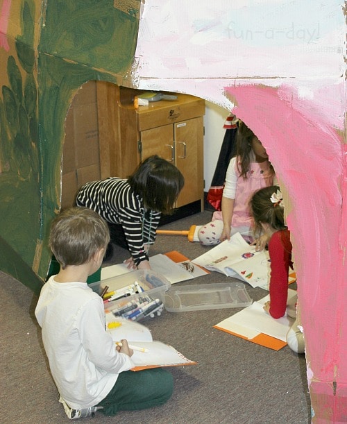 preschoolers in dramatic play center with large DIY cardboard castle they helped make