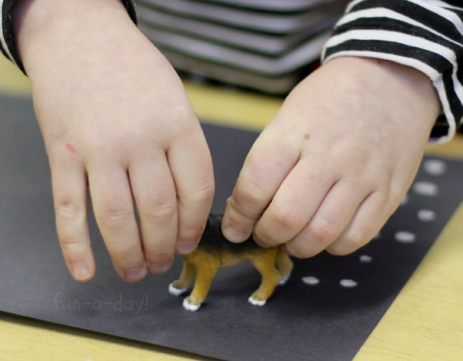 preschooler using toy dog to create art